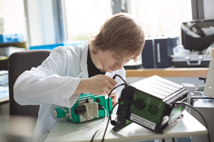 USMS | US Medical Systems | male technician repairing machine at table in workshop